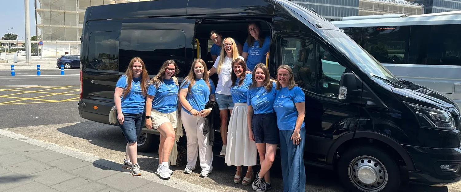 Group of passengers with a black BCN Minibus van at the airport